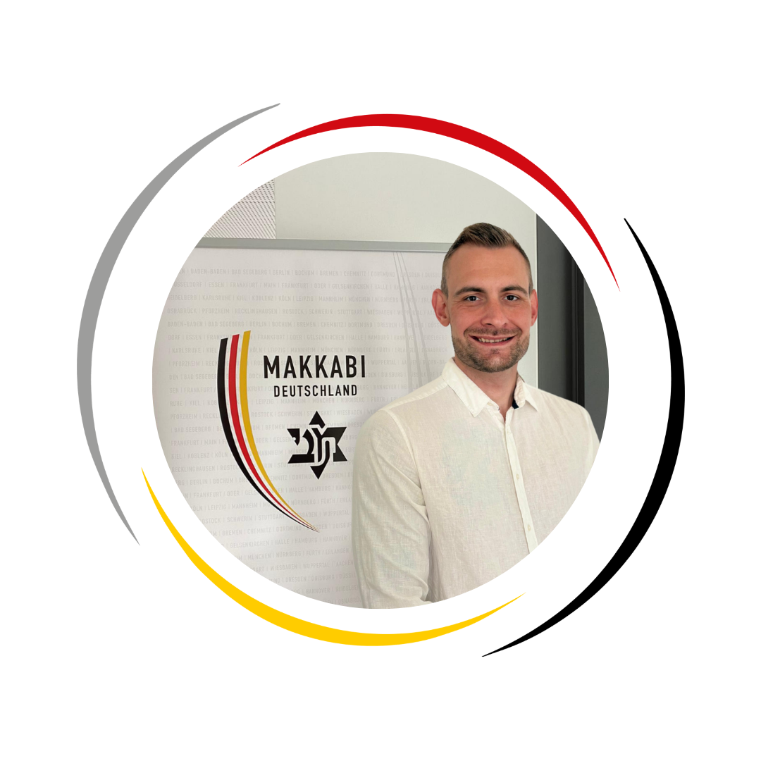 Portraitaufnahme von Andreas Kult vor dem Makkabi Logo im Hintergrund